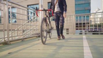 Geschäftsmann in formeller Kleidung, der sein Fahrrad in der Hauptverkehrszeit durch die grüne Überführung über den Stau schiebt, junger professioneller Mann genoss es, auf der Straße in der Stadt zu laufen, abseits vom Verkehr video