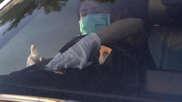 uitzicht vanaf de voorruit aziatische vrouw draag beschermende maskers en handschoenen desinfecterende auto stuur doekjes, ontsmettende spray car wash, covid-19 virus, nieuw normaal, stoffig vuil voorruitglas video