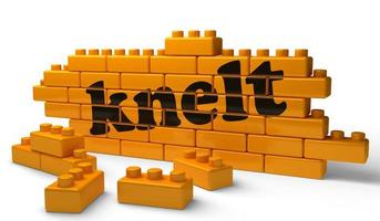 knelt word on yellow brick wall photo