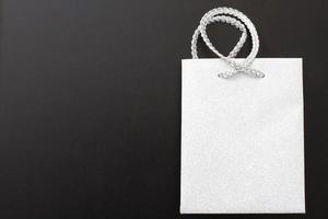 Empty white shopping bag for advertising and branding on black background. Mock up and copy space photo