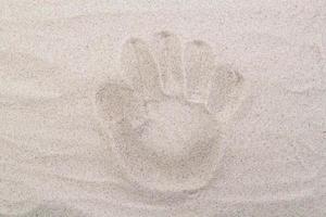 Palm footprint in the sand top view. Sand copy space. Sand background top view. photo