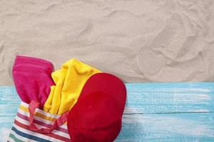 Sand copy space. Sand background top view. Beach towels in a beach bag and a red cap photo