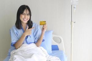 A young patient woman is holding credit card , admitting in hospital , Health care  concept photo