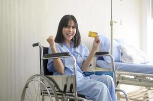 A young patient woman is holding credit card , admitting in hospital , Health care  concept photo