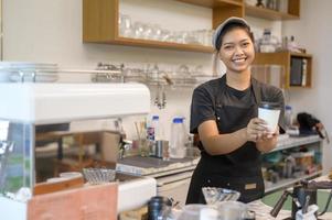 joven barista con mentalidad de servicio que trabaja en una cafetería foto