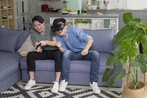 Young smiling gay couple playing video games in the living room at home, LGBTQ and diversity photo