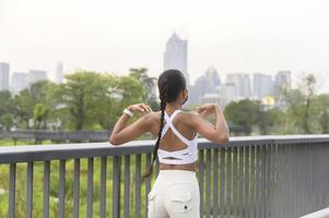Young fitness woman in sportswear wearing face mask  while exercise  in city park, Health and Lifestyles. photo
