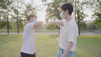 New normal greeting style, two asian male say hi to each other with elbows bumps, meet up communication during epidemic, less contact avoidance, social distancing during lockdown pandemic crisis video