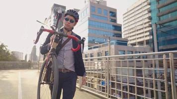 gelukkig ontspannen fietsliefhebber man met helm op hoofd duwen zijn fiets door viaduct over slecht verkeer in de spits. jonge professional geniet van uitzicht op de straat in de stad, weg van het verkeer video