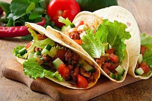 Mexican tacos with meat, vegetables and cheese photo