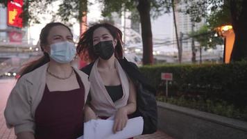deux femmes asiatiques travaillant dans un bureau se précipitant au travail, situation d'urgence, étant en retard au travail, employés de bureau occupés courant avec une tenue d'affaires formelle se précipitent dans le bâtiment, protection par masque facial