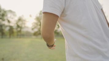 Young happy asian man holding a medical mask with enjoys playing running inside green fresh park, people freedom after covid-19 pandemic, touching a nature, relaxing exercise, emotional relief concept video