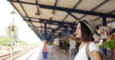 Porträt einer jungen asiatischen Reisenden, die am Bahnhof ein Foto vor der Kamera macht. frau, die kamera betrachtet. transport-, urlaubs- und reisekonzept. video