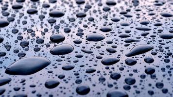 gotas de chuva caindo em uma placa cinza refletida no céu e nuvens, o padrão de gotas de chuva em um metal cinza. video