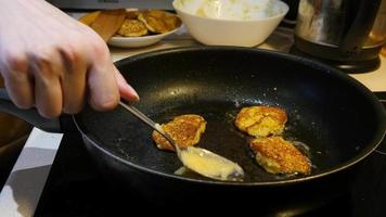 fritar panquecas de batata em uma panela na cozinha - comida vegetariana video