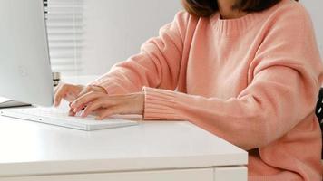 Young woman working at a desk with a computer keyboard. video