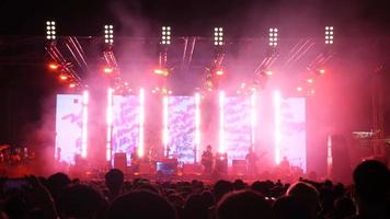 la multitud en el concierto y las luces borrosas del escenario de la gente bailando en el concierto de rock 'n roll. video