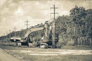 Excavators and other industrial vehicles destroy the jungle Tulum Mexico. photo