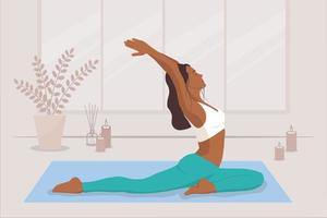 A dark-skinned young woman does yoga in a bright room with candles vector