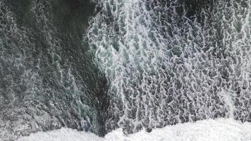 Luftaufnahme von Wellen, die auf Felsen in einem blauen Ozean brechen. Meereswellen am schönen Strand Luftaufnahme Drohne 4k Schuss. video