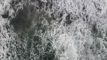 vista aérea de arriba hacia abajo de las olas gigantes del océano rompiendo y formando espuma video