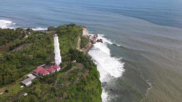 Luftaufnahme des tropischen Strandes in Indonesien mit Leuchtturm und traditionellem Boot. video