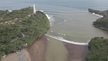 Aerial view of Tropical Beach in Indonesia with lighthouse and traditional boat.