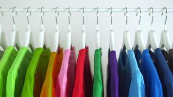 Close up of Colorful t-shirts on hangers, apparel background, Slider shot
