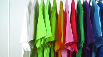 close-up van kleurrijke t-shirts op hangers, kledingachtergrond, slider shot video