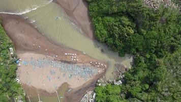 vista aérea superior de playa tropical en indonesia con faro y barco tradicional. video