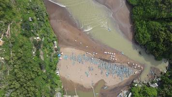 Aerial top view of Tropical Beach in Indonesia with lighthouse and traditional boat. video