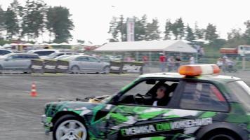 coche a la deriva, conductor profesional. coche de carreras a la deriva con humo espeso de neumáticos quemados. agotamiento de autos de carrera. en coche texto en física rusa del movimiento. ucrania, kiev - 22 de julio de 2021. video