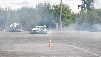 coche a la deriva, conductor profesional. coche de carreras a la deriva con humo espeso de neumáticos quemados. agotamiento de autos de carrera. en coche texto en física rusa del movimiento. ucrania, kiev - 22 de julio de 2021. video