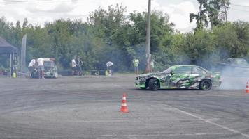 coche a la deriva, conductor profesional. coche de carreras a la deriva con humo espeso de neumáticos quemados. agotamiento de autos de carrera. en coche texto en física rusa del movimiento. ucrania, kiev - 22 de julio de 2021. video