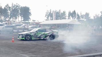 coche a la deriva, conductor profesional. coche de carreras a la deriva con humo espeso de neumáticos quemados. agotamiento de autos de carrera. en coche texto en física rusa del movimiento. ucrania, kiev - 22 de julio de 2021. video