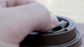 la main d'un homme ouvre un abreuvoir à couvercle en plastique sur une tasse à café en papier jaune. nourriture à emporter. un homme boit du café ou du thé chaud au restaurant de restauration rapide mcdonald's. ukraine, kiev - 12 septembre 2021. video