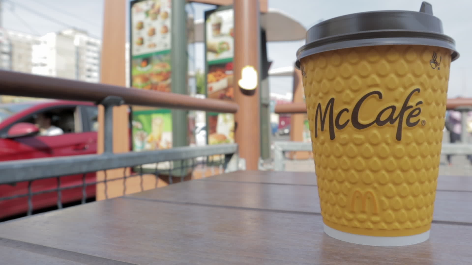 Yellow cardboard coffee cup from McDonald's. Mc Cafe paper glass drink. One coffee cup on the