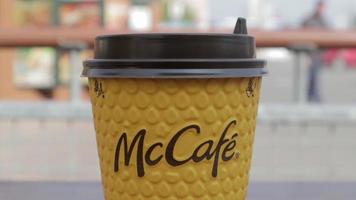 tasse à café en carton jaune de mcdonald's. boisson en verre papier mc café. une tasse de café sur la table avec du thé ou du café chaud. menu dans un fast-food. ukraine, kiev - 12 septembre 2021. video