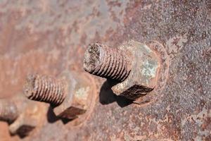 Rusty nuts and bolts on an old metal structure. photo