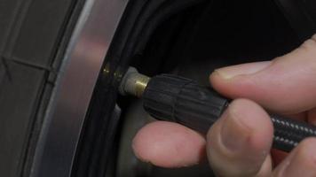 Inflating tire. man hand open valve cap and inflate car tyre before driving. video