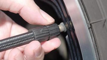 Inflating tire. man hand open valve cap and inflate car tyre before driving. video