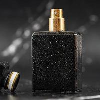 hermosa botella de perfume sobre fondo de mármol negro foto