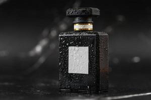 beautiful perfume bottle on black marble background photo