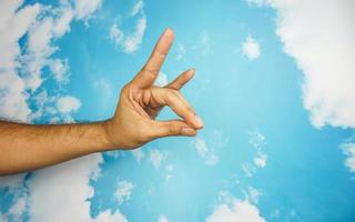 hand symbol isolated from sky background. concept of sign language photo