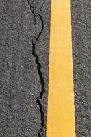línea amarilla de asfalto agrietado foto