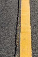 Cracked asphalt Yellow line photo