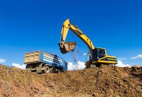 Backhoe digging and trucks. photo