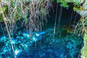 Blue turquoise water limestone cave sinkhole cenote Tajma ha Mexico. photo