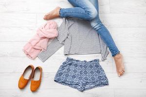 Collection collage of women's clothing and female legs on white wooden background. Top view photo