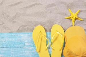 Sand copy space. Sand background top view.Beach towel, beach slippers, yellow bluzer and starfish photo